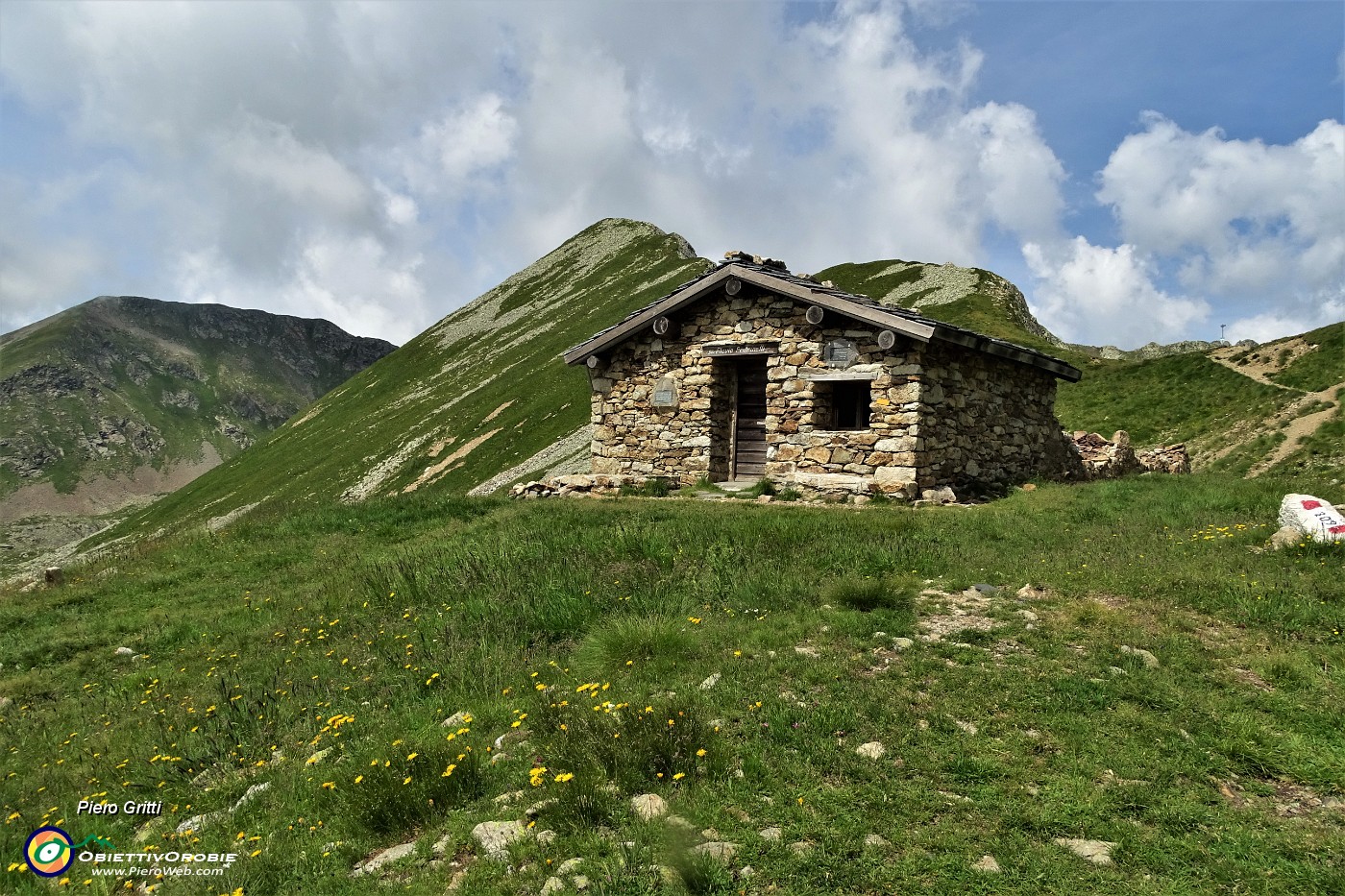 41 Bivacco Pedrinelli (2253 m) con vista a dx al Passo di Pubino (2368 m).JPG